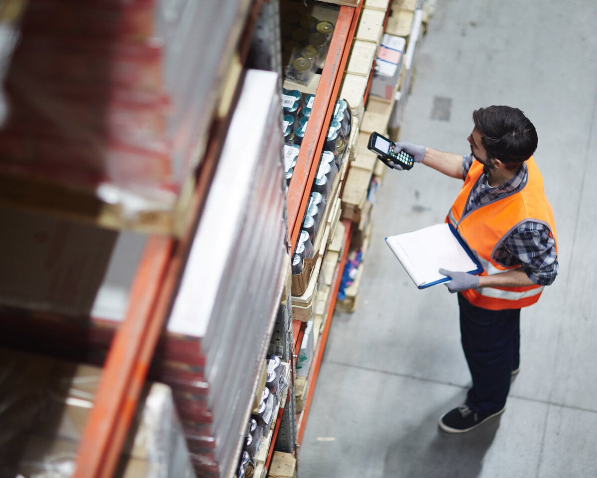Arbeiter mit Scanner bei der Überprüfung von Waren im Lager