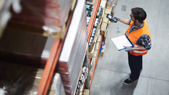 Arbeiter mit Scanner bei der Überprüfung von Waren im Lager