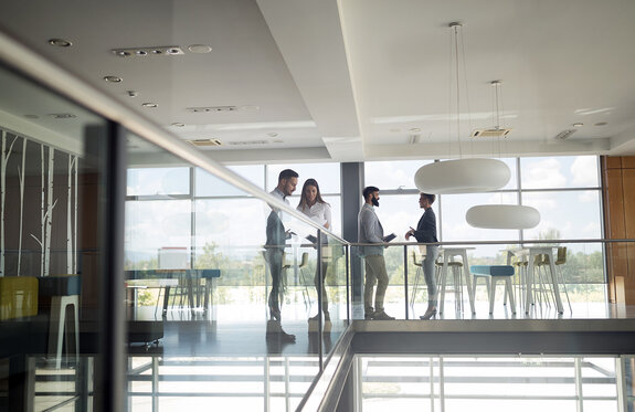 Eine Gruppe von Geschäftsleuten, die in einem Büro gehen und eine Treppe hinaufsteigen 