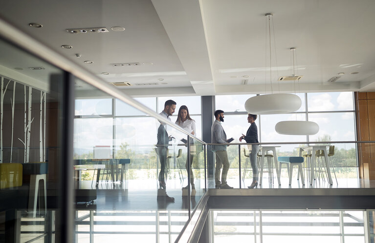 Eine Gruppe von Geschäftsleuten, die in einem Büro gehen und eine Treppe hinaufsteigen 