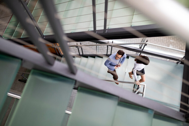 Junge Geschäftsleute steigen im Büro die Treppe hinauf 
