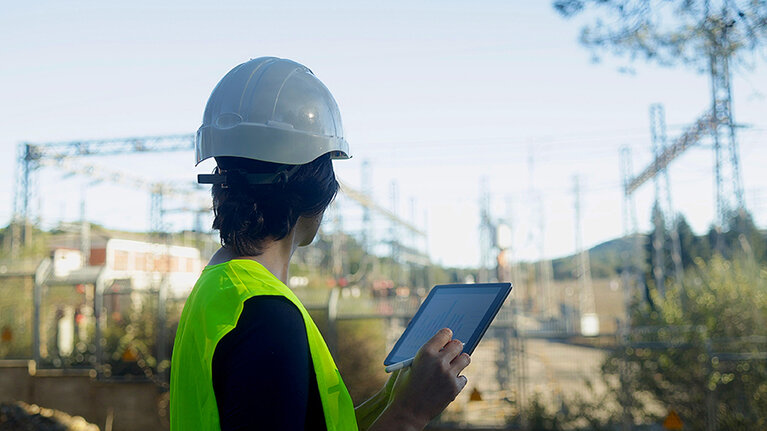 Ingenieur oder Fachkraft, der/die Stromleitungen und Anlagen in einem Freiluft-Umspannwerk inspiziert und überwacht und vor Ort in einem Hochspannungskraftwerk tätig ist