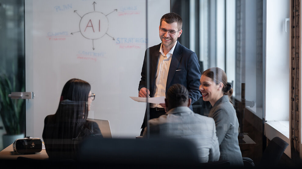 Ein vielfältiges Geschäftsteam in einem modernen Büro während einer Besprechung, bei der die Strategie im Bereich künstliche Intelligenz erörtert wird. Konzept der KI-Innovation, Teamarbeit, Führung, Unternehmensplanung, professionelle Zusammenarbeit