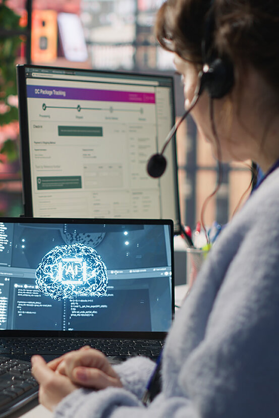  Mitarbeiter im Live-Chat-Support, der auf der Tastatur tippt und einen KI-Chatbot nutzt, um Kundenbeschwerden zu bearbeiten. Callcenter-Mitarbeiter, der sich mithilfe von künstlicher Intelligenz (LLM) und einer Kamera um unzufriedene Kunden kümmert