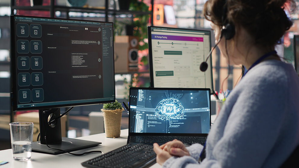  Mitarbeiter im Live-Chat-Support, der auf der Tastatur tippt und einen KI-Chatbot nutzt, um Kundenbeschwerden zu bearbeiten. Callcenter-Mitarbeiter, der sich mithilfe von künstlicher Intelligenz (LLM) und einer Kamera um unzufriedene Kunden kümmert
