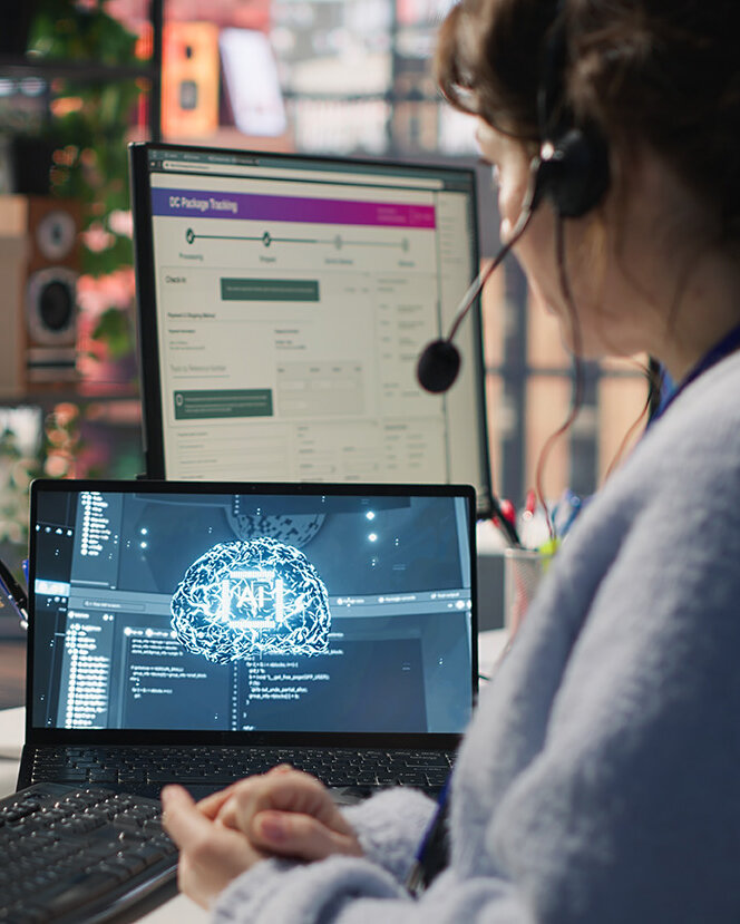  Mitarbeiter im Live-Chat-Support, der auf der Tastatur tippt und einen KI-Chatbot nutzt, um Kundenbeschwerden zu bearbeiten. Callcenter-Mitarbeiter, der sich mithilfe von künstlicher Intelligenz (LLM) und einer Kamera um unzufriedene Kunden kümmert