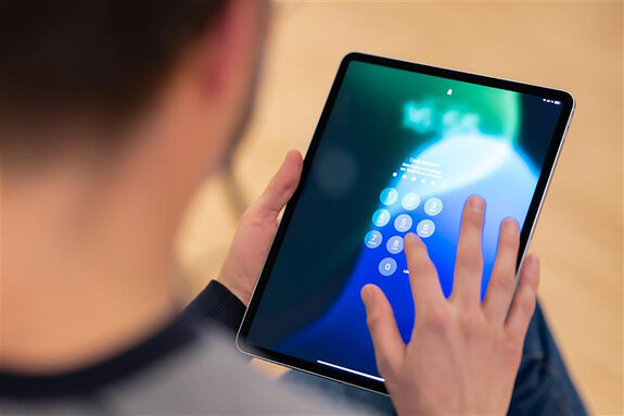 Mann tippt etwas auf einem Tablet