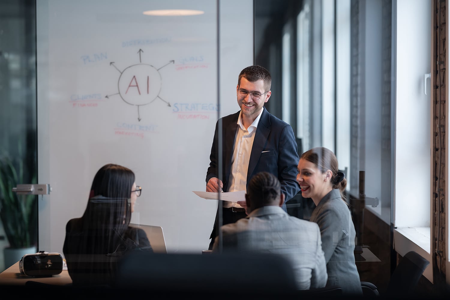 Ein vielfältiges Geschäftsteam in einem modernen Büro während einer Besprechung, bei der die Strategie im Bereich künstliche Intelligenz erörtert wird. Konzept der KI-Innovation, Teamarbeit, Führung, Unternehmensplanung, professionelle Zusammenarbeit