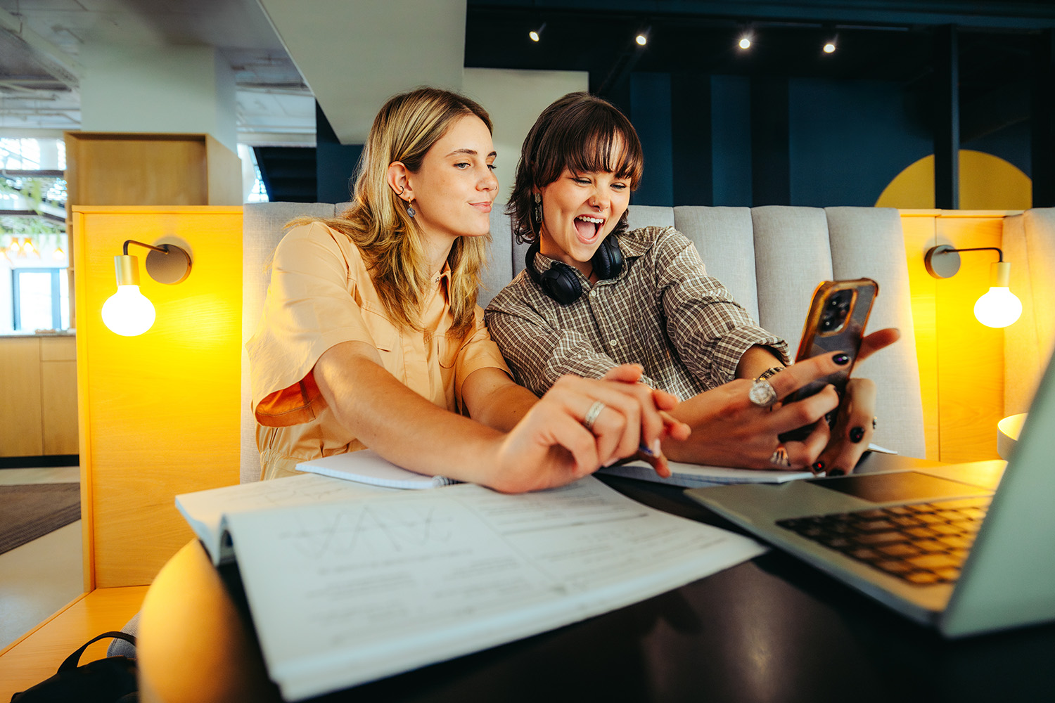 Begeisterte Studenten der Generation Z machen ein Selfie in einer Bibliothek, während sie an einem Projekt arbeiten
