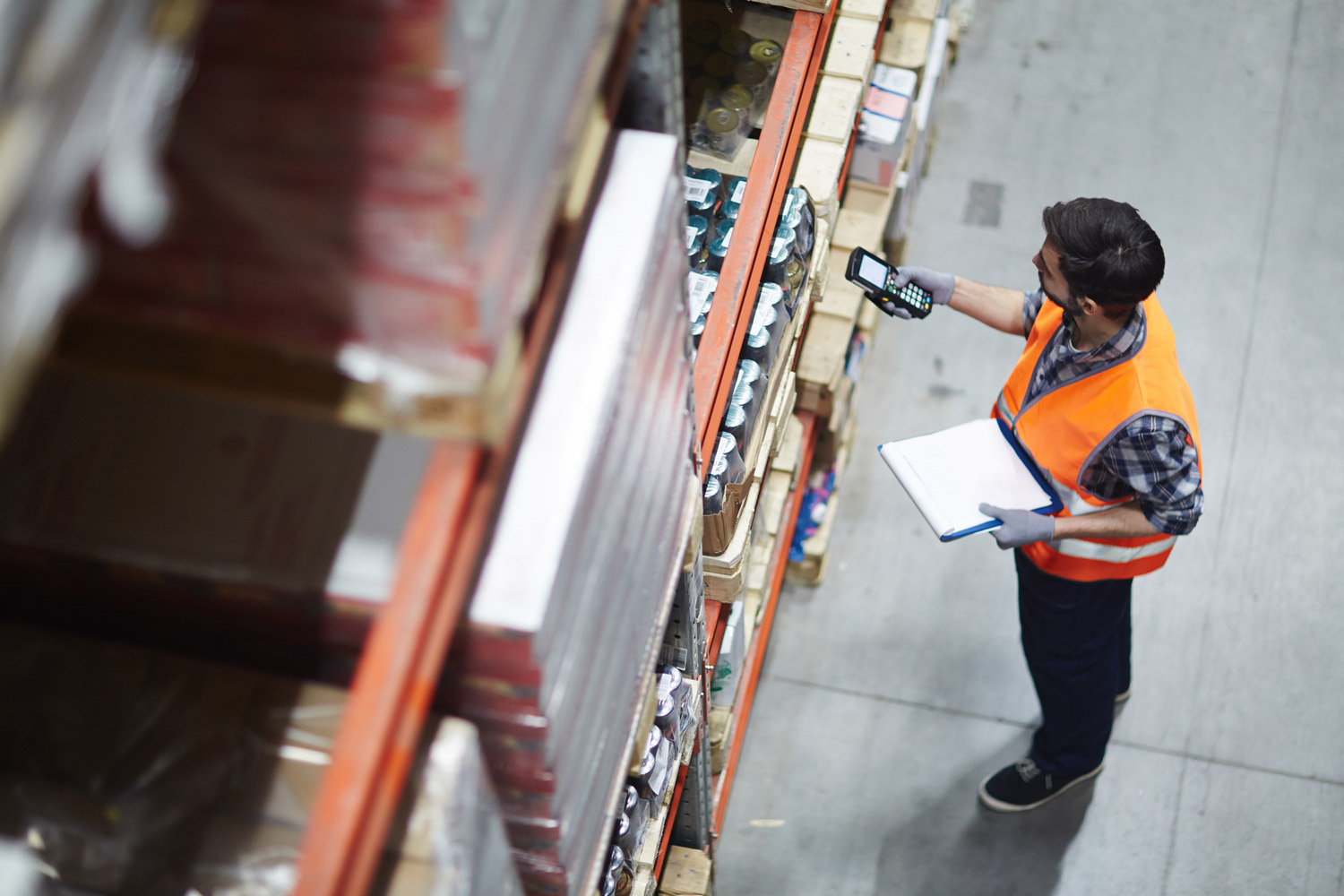 Arbeiter mit Scanner bei der Überprüfung von Waren im Lager