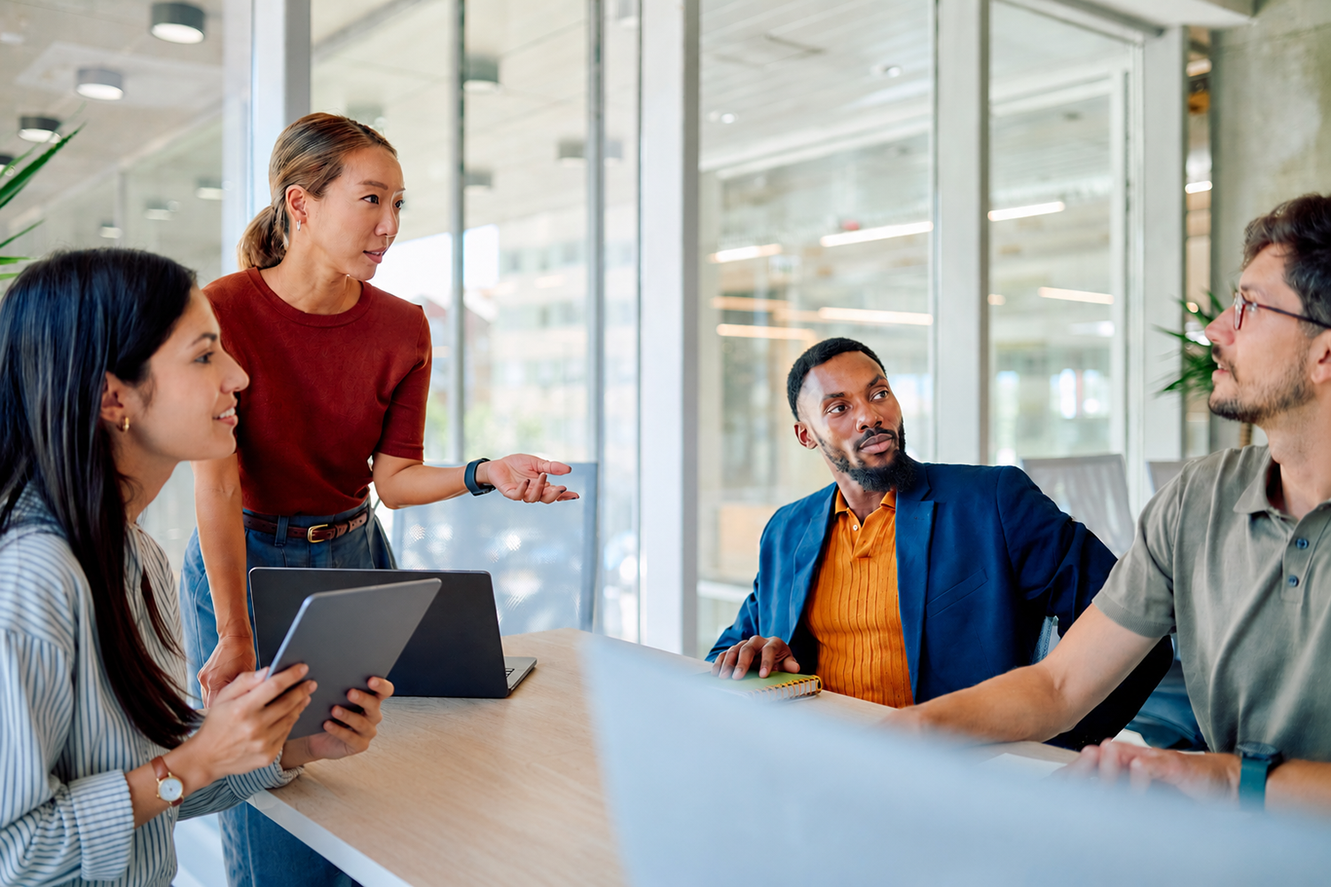 Ein Geschäftsteam arbeitet während einer Besprechung in einem modernen Büro gemeinsam an einem Projekt und tauscht Ideen und Strategien für den Erfolg aus 