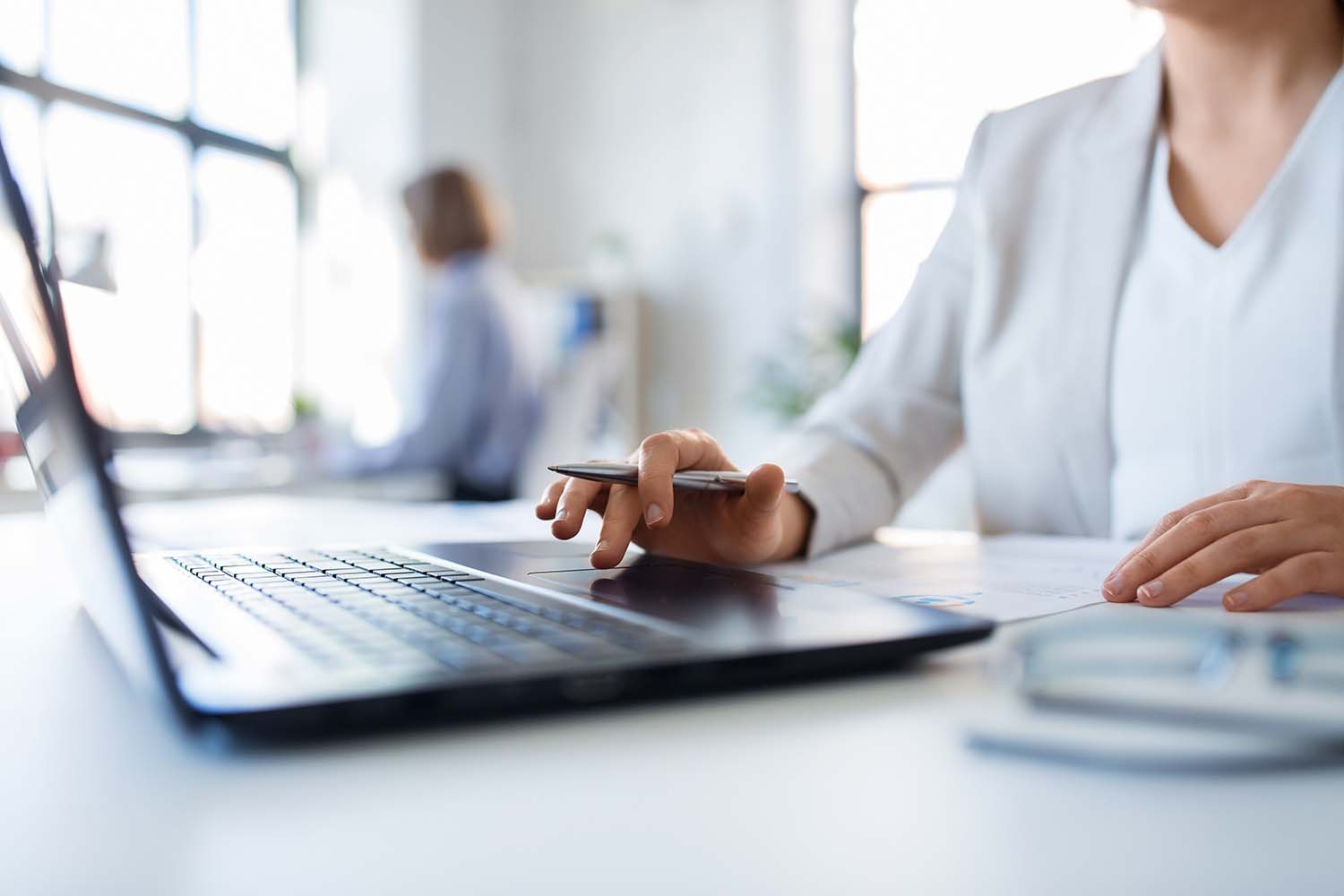 Konzept „Business und Menschen“ – Geschäftsfrau mit Laptop und Unterlagen bei der Arbeit im Büro